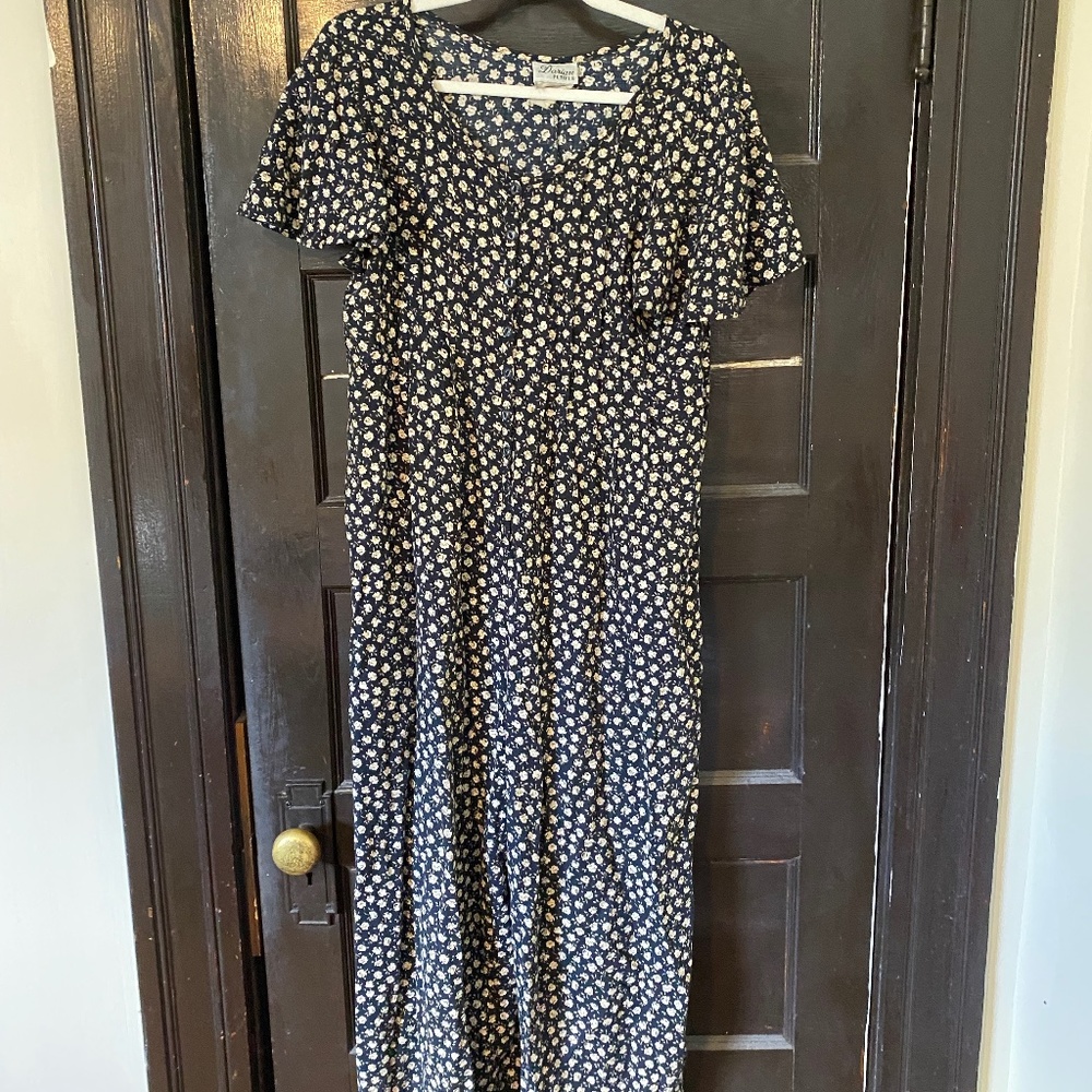 Black onesie/jumpsuit with white flower pattern and buttons down the front